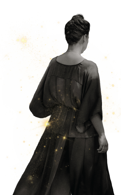 Portrait of Ivana facing away, wearing a flowing gown with gold flecks on a soft white background